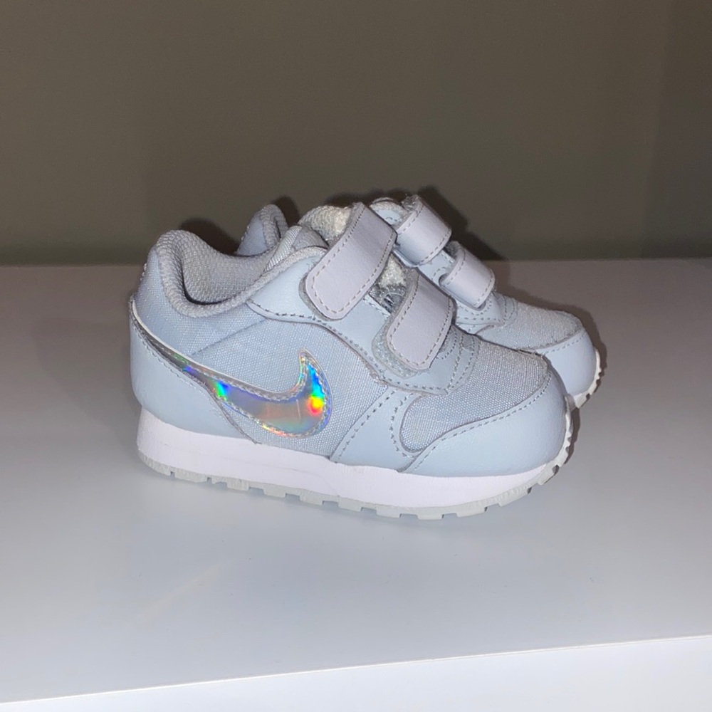 Nike. Light grey with shades of pink and white glow on the nike sign. Size 4
